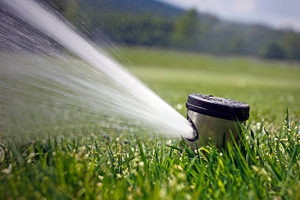 Arizona irrigation system maintenance in Phoenix desert landscape showing technician servicing sprinkler heads